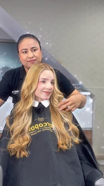 Estilista con clienta de cabello rubio ondulado